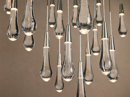 Soltaire Round Chandelier with many clear, textured glass teardrops, suspended from thin wires with polished silver caps.