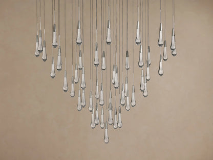 Soltaire Round Chandelier: Many clear glass teardrop pendants with silver-toned tops, suspended and emitting a warm glow.