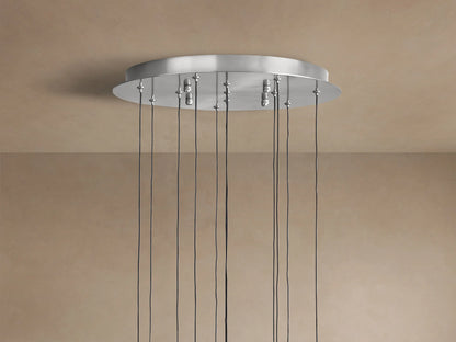 Close-up of Soltaire Round Chandelier with clear, teardrop glass pendants, internal bubbles, chrome accents, and warm glowing light.