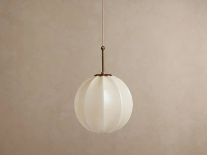 Agnes Pendant: Spherical, paneled cream glass shade glowing warmly, hanging from an antique brass rod & thin wire.