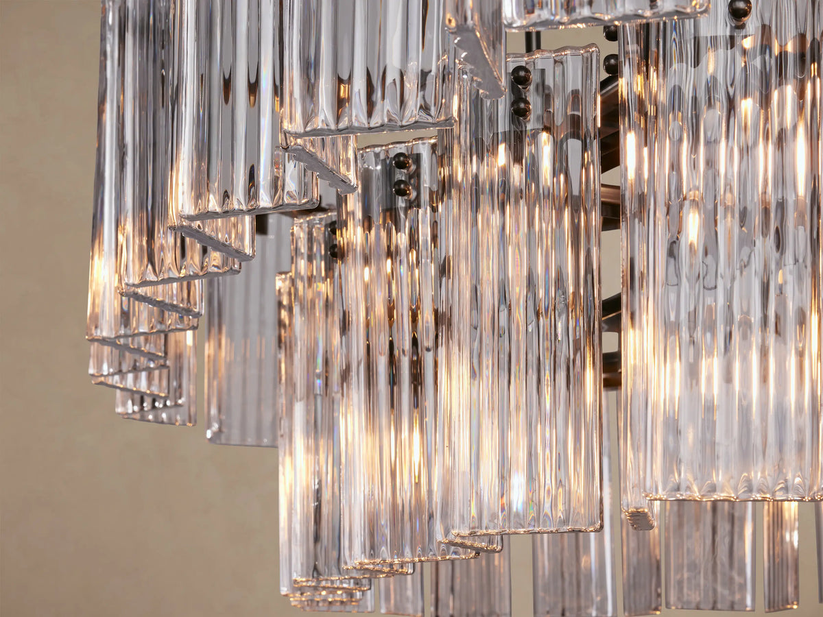 Delsie Oval Tiered Chandelier: Oval fixture, clear fluted glass rods in two tiers, dark metal frame, suspended.