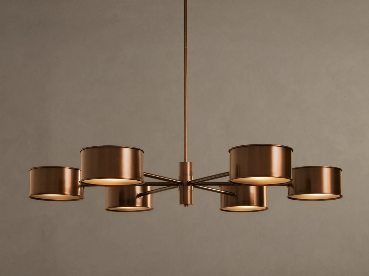 Daphne Metal Round Chandelier in warm bronze with six cylindrical shades, hanging from a rod, lights illuminated.