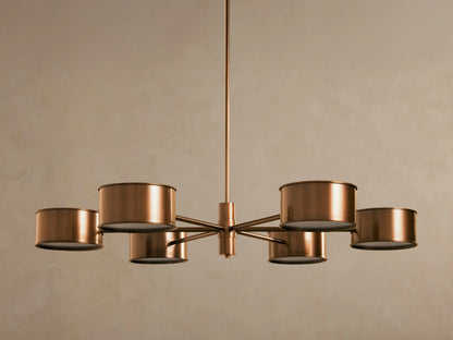 Daphne Metal Round Chandelier in warm bronze with six cylindrical shades, hanging from a rod, lights illuminated.