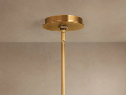 Daphne Metal Round Chandelier, antique brass finish. Close-up of several illuminated cylindrical shades emitting warm light.