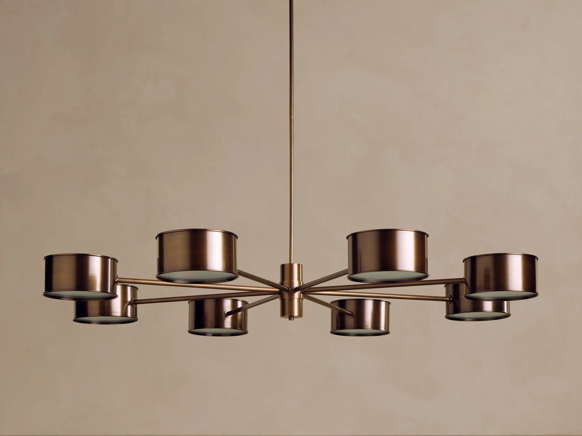Bronze-finished Daphne Metal Round Chandelier with 8 cylindrical metal shades radiating a warm, downward glow.