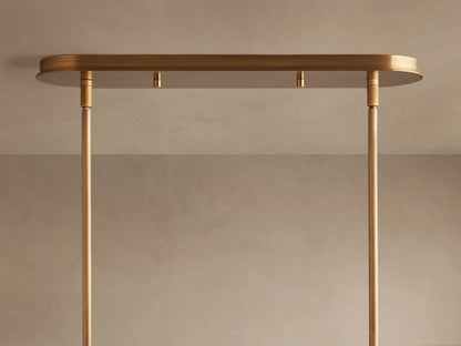 Close-up of Daphne Metal Linear Chandelier, showing several warm bronze shades with bright, glowing lights and connecting rods.