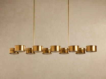 Daphne Metal Linear Chandelier: Antique brass fixture, 10 illuminated cylindrical shades arranged horizontally, suspended.