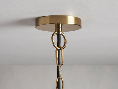Three Bauer Dome Pendant lights hang at different heights against a gray background, each with a clear glass shade and brass finish.
