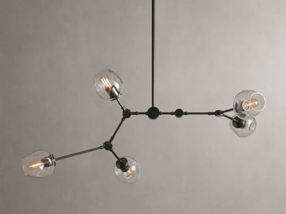 Noella Bronze Chandelier with five arms, clear glass bulb covers, and a sleek bronze finish against a light gray background.