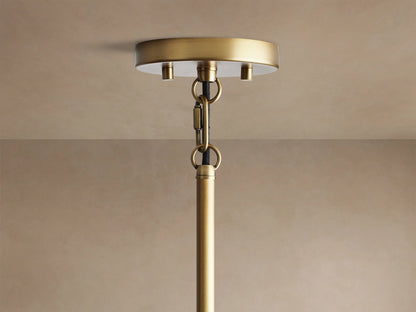 Andreas Pendant, a close-up of its brushed bronze metalwork and ribbed clear glass shade with a glowing filament bulb.