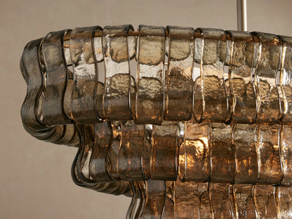 Ghiaccio Oval Chandelier with multi-tiered smoky bronze textured curved glass panels, suspended horizontally by two brass chains.