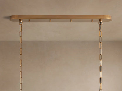 Smoky, wavy, textured glass panels of the Ghiaccio Oval Chandelier, reflecting warm light from within.