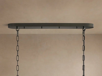Close-up of Ghiaccio Oval Chandelier, showing wavy, textured dark glass panels with warm light glowing from within.