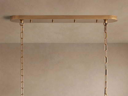 Close-up of Ghiaccio Oval Chandelier with layered, wavy, textured clear glass bands, glowing warmly from within.