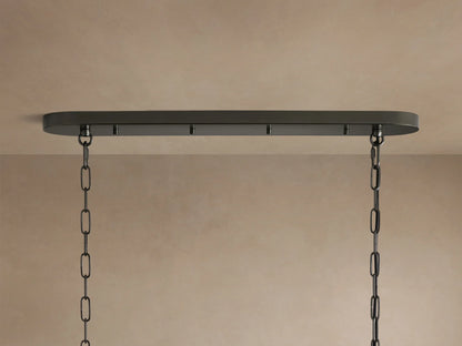 Close-up of a glowing Ghiaccio Oval Chandelier, featuring multiple tiers of curved, textured, smoky glass pieces.