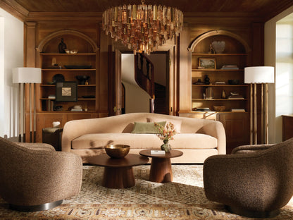 Neve Round Chandelier, illuminated, featuring tiered bronze cast glass and brass rods suspended from a ceiling chain.