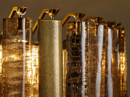 Neve Round Chandelier close-up: Alternating textured bronze glass & brass aluminum cylinders, glowing warmly.