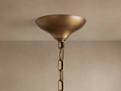 Neve Round Chandelier's textured brass ceiling canopy and chain, mounted on a light beige ceiling.