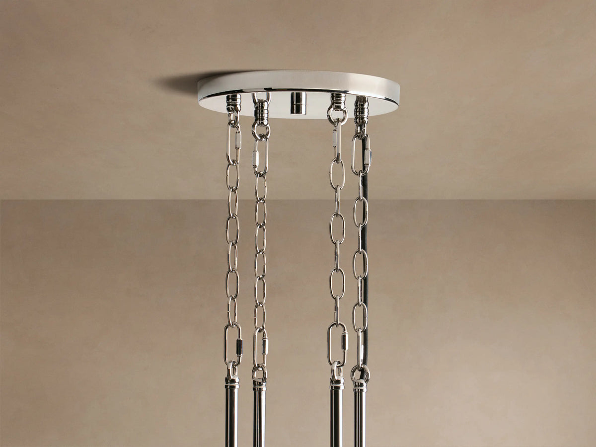 Close-up of Andreas Round Chandelier: polished nickel frame, clear fluted glass, glowing amber filament bulbs.