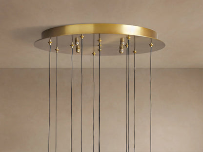 Top of Soltaire Round Chandelier with a brass circular canopy mounted on a light ceiling, many black cords hang down.