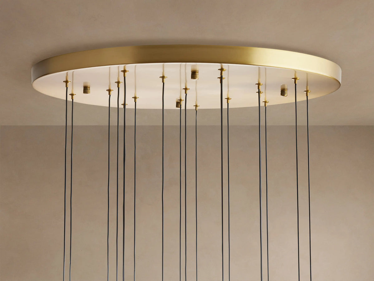 Soltaire Round Chandelier with a brass-finished rim, white ceiling plate, and many thin black cords hanging down.