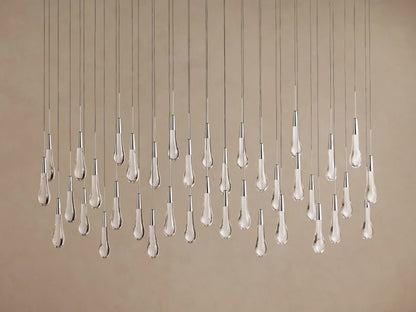 Soltaire Linear Chandelier with many sparkling clear teardrop glass pendants hanging vertically from thin wires, metallic accents.