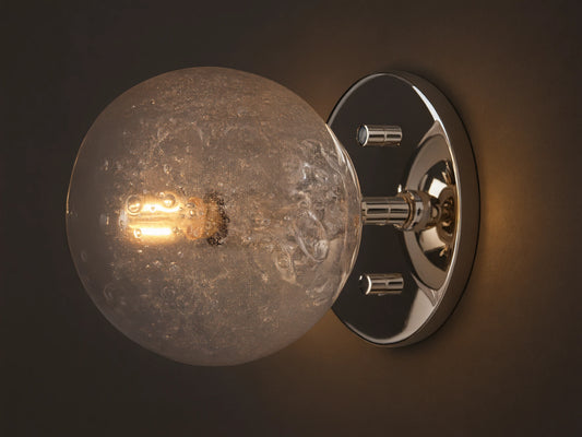 Mandoza Sconce with polished nickel-finished steel base featuring a textured hand-blown glass globe, mounted on a wall.