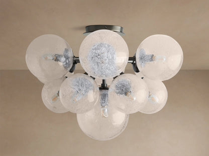 Mandoza Flush Mount with multiple clear, bubbled hand-blown glass globes on a dark metal frame, illuminated.