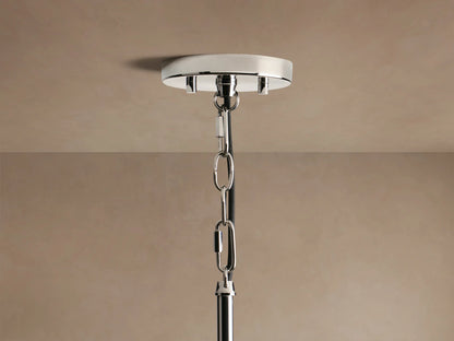 Close-up of Andreas Pendant, a cylindrical light with clear ribbed glass shade, polished nickel, and warm filament bulb.