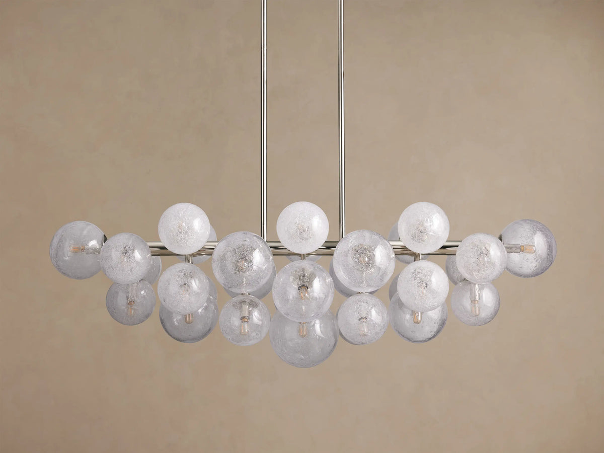 Mandoza Linear Chandelier with polished nickel frame, many illuminated, textured glass globes casting a warm glow.