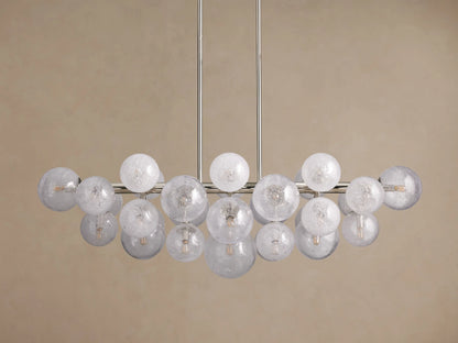 Mandoza Linear Chandelier with polished nickel frame, many illuminated, textured glass globes casting a warm glow.