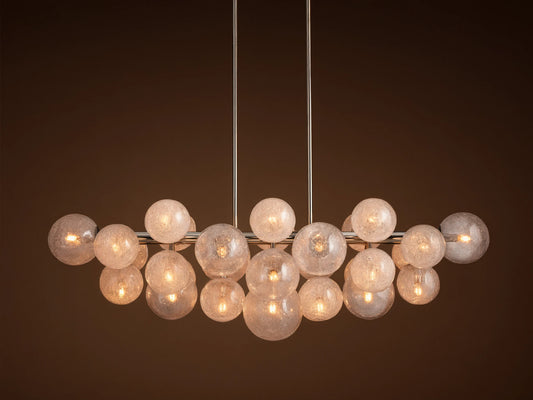 Mandoza Linear Chandelier with polished nickel frame, many illuminated, textured glass globes casting a warm glow.
