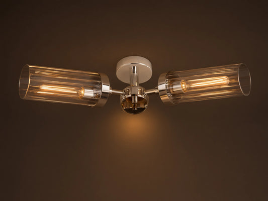 Andreas Flush Mount, polished nickel, with two horizontal clear ribbed glass shades, showcasing glowing filament bulbs.