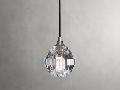 Amoroso Pendant with faceted crystal shade hanging from a black cord, showcasing a dimmable LED bulb inside.