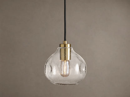Organic 8" Pendant: Clear, seeded mouth-blown glass shade with brass hardware, black cord, and a glowing Edison bulb.