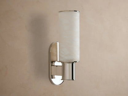 Harlin Sconce: vertical glowing alabaster cylinder, polished nickel racetrack backplate and base, mounted on a neutral wall.