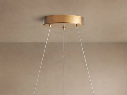 Close-up of Lyla Chandelier with hand-blown white glass petals and glowing integrated LEDs on a plated brass frame.