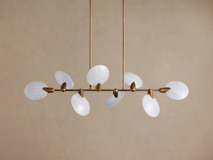 Lyla Linear Chandelier with 8 milky white oval hand-blown glass shades on an aged brass horizontal bar, suspended by two rods.