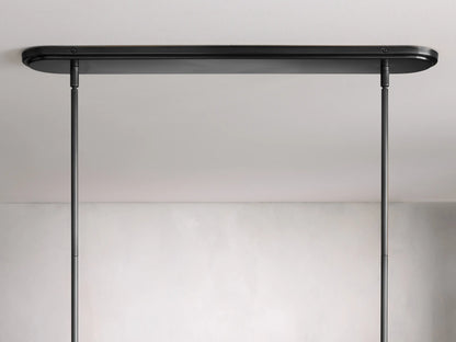 Rhodes Linear Chandelier features black metal rods with intricate detailing and white tapered linen shades against a neutral background.