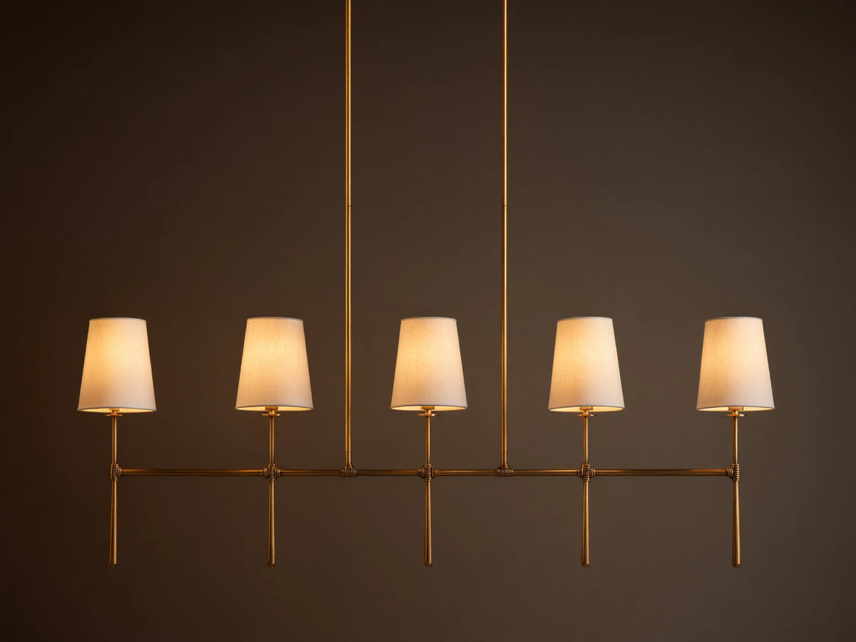 Rhodes Linear Chandelier, burnished brass finish, 5 lights with tapered off-white linen shades.