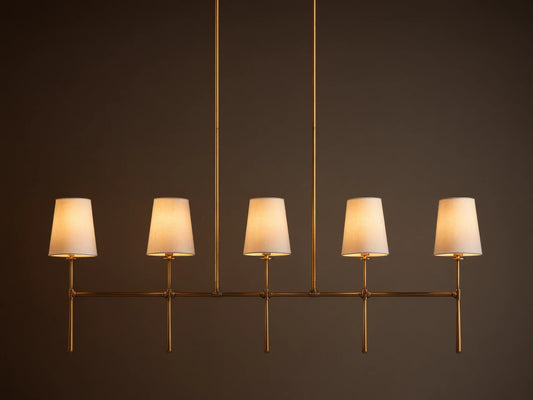 Rhodes Linear Chandelier, burnished brass finish, 5 lights with tapered off-white linen shades.
