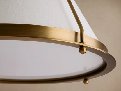 Shelton Flush Mount. Burnished brass metal frame supports a tapered off-white linen shade and clear diffuser, mounted on a ceiling.