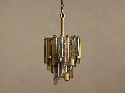 Neve Pendant, hanging, featuring a brass frame with tiered bronze cast glass panels, emitting a warm, inviting glow.