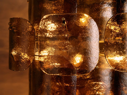 Blaire Round Chandelier with glowing pearlescent white molten glass panels showing bubbled texture, against a warm brown background.