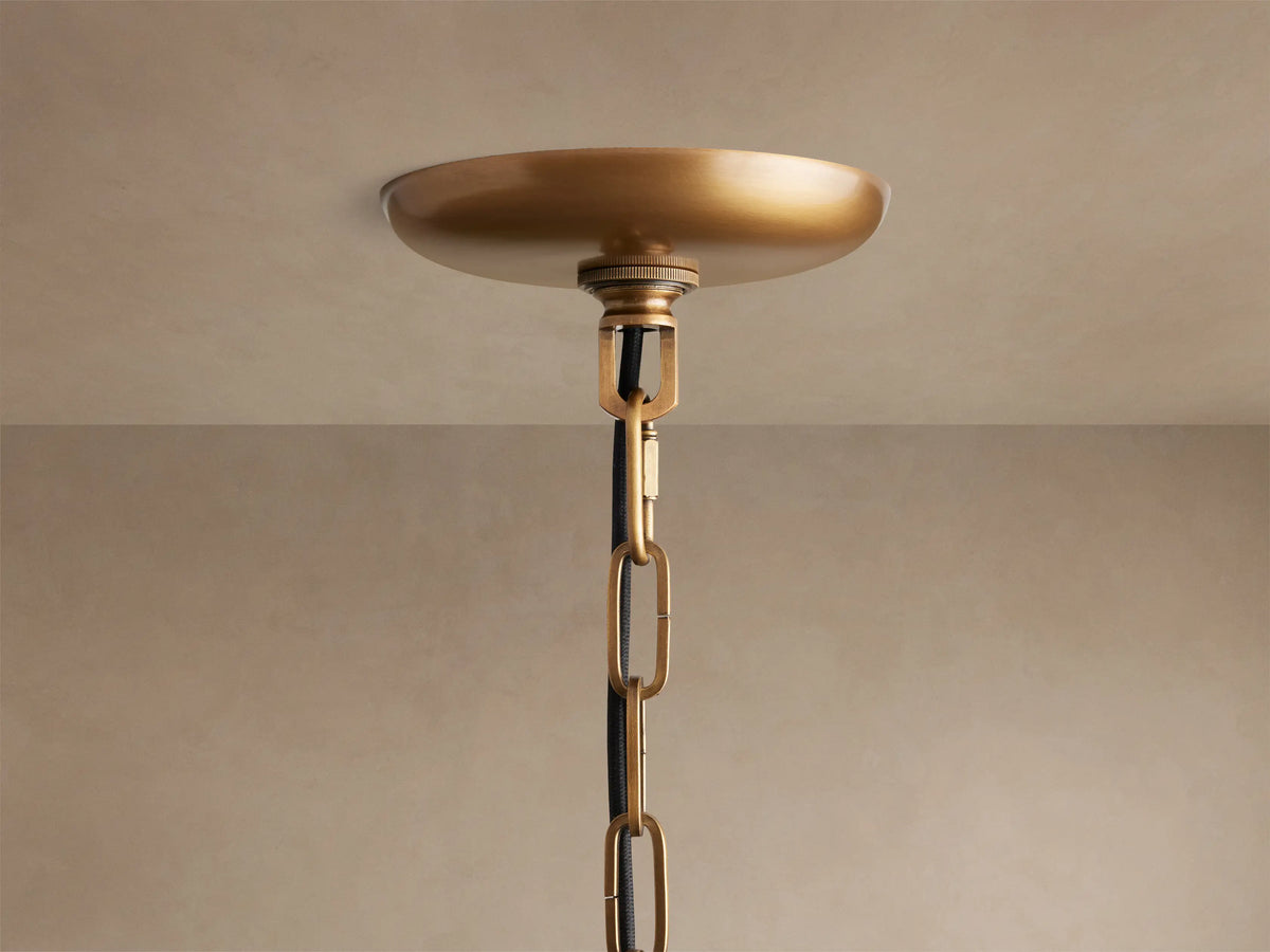 Ghiaccio Pendant with wavy, textured glass panels illuminated from within, creating a warm, ambient glow against a neutral background.