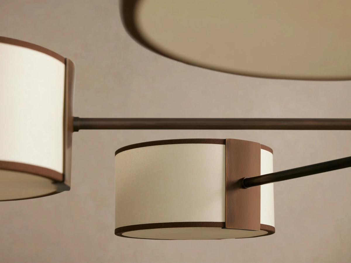 Daphne Fabric Round Chandelier with 8 dark bronze arms holding white linen shades with black trim, hanging from above.