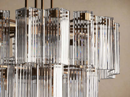 Delsie Round Chandelier with three tiered rings of clear fluted glass rods, suspended by dark bronze-colored metal rods.