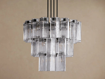 Delsie Round Chandelier, multi-tiered with clear ribbed glass rods and dark metal frame, hanging against a solid brown wall.