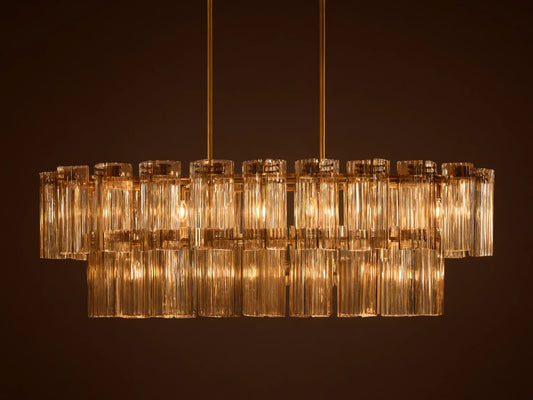 Delsie Oval Tiered Chandelier, burnished brass finish, two tiers of illuminated fluted glass rods on a simple background.
