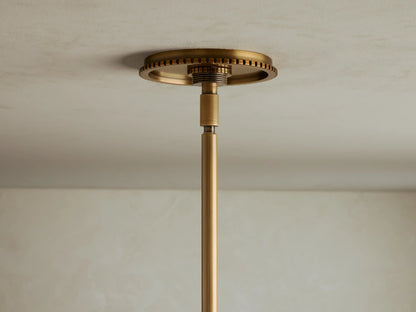 Close-up view of a brass lighting fixture with clear spherical glass shades and exposed filament bulbs.